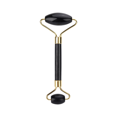 Black and gold facial roller on a white background